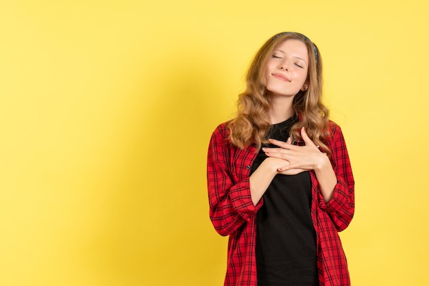 Vooraanzicht jonge vrouw in rood geruit overhemd poseren op gele achtergrond meisjes emotie kleur menselijk model vrouw