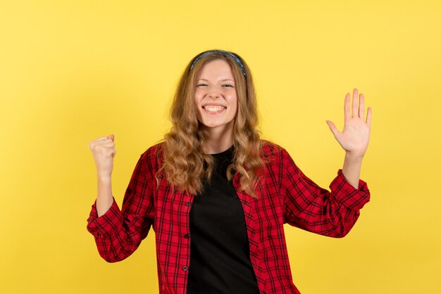 Vooraanzicht jonge vrouw in rood geruit overhemd staande op gele achtergrond meisjes menselijke kleur model vrouw