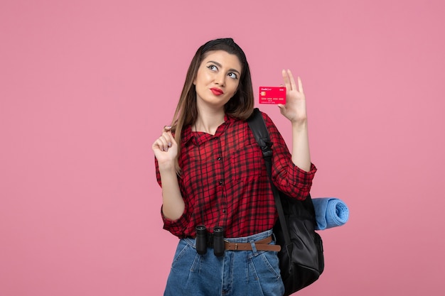 Vooraanzicht jonge vrouw in rood shirt met bankkaart op lichtroze achtergrond vrouw kleur mens