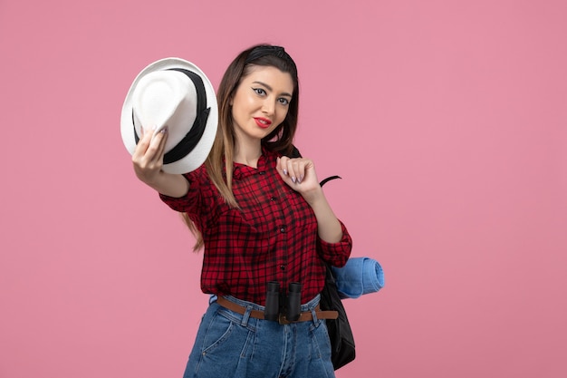 Vooraanzicht jonge vrouw in rood shirt met hoed op lichtroze achtergrond menselijke kleur vrouw