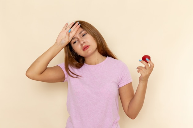 Vooraanzicht jonge vrouw in roze t-shirt en spijkerbroek met zure pruim slecht gevoel
