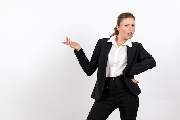 Vooraanzicht jonge vrouw in strikt klassiek pak poseren op een witte achtergrond vrouw baan bedrijf werk kostuum vrouw