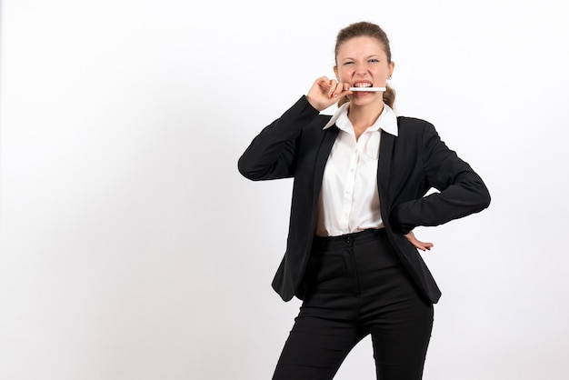 Vooraanzicht jonge vrouw in strikte klassieke pak met pen op witte achtergrond vrouw baan kostuum zakelijke vrouwelijke werk