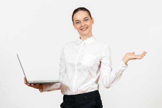 Vooraanzicht jonge vrouw in witte blouse met behulp van laptop en glimlachend op witte achtergrond baan kantoor vrouw gevoel model emotie