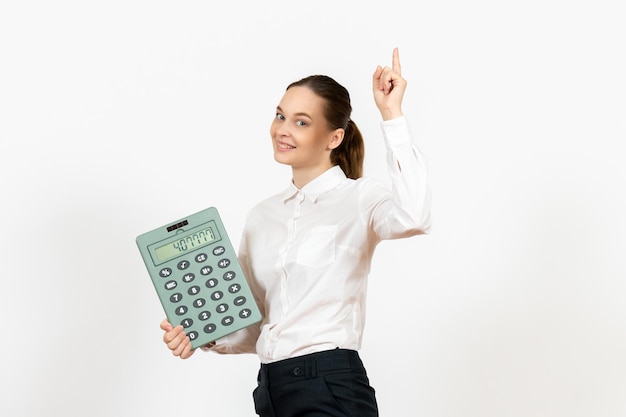 Vooraanzicht jonge vrouw in witte blouse met grote rekenmachine op witte achtergrond kantoor vrouwelijke emotie gevoelens baan werknemer white