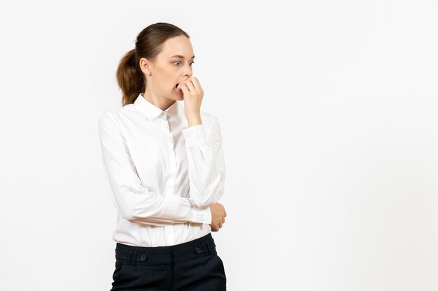 Vooraanzicht jonge vrouw in witte blouse met nerveus gezicht op witte achtergrond kantoorbaan vrouwelijke emotie gevoel model