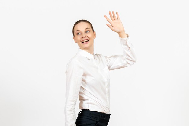 Vooraanzicht jonge vrouw in witte blouse met opgewonden uitdrukking op witte achtergrond vrouwelijk model kantoor emoties baan gevoel