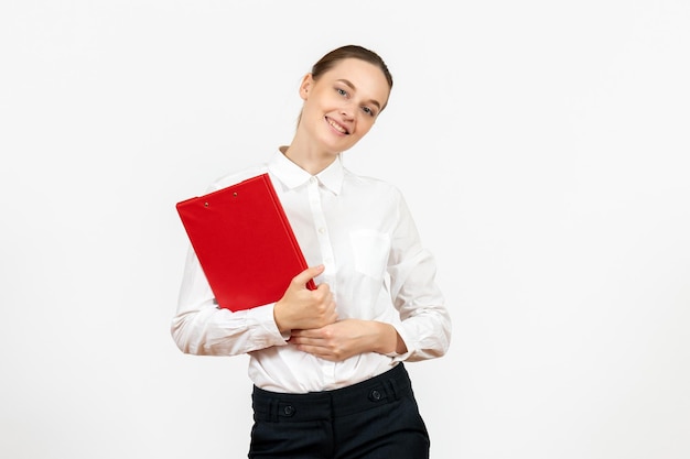 Vooraanzicht jonge vrouw in witte blouse met rood bestand in haar handen op witte achtergrond kantoorbaan vrouwelijke emoties gevoelens model