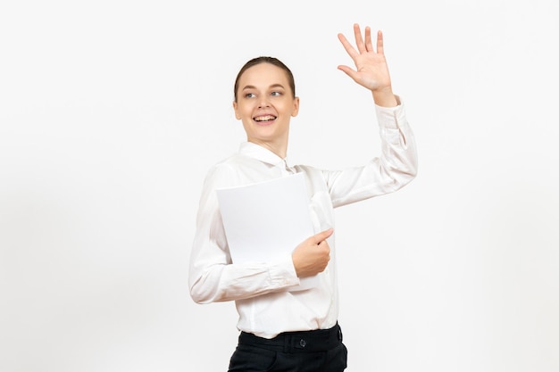 Vooraanzicht jonge vrouw in witte blouse met verschillende documenten op witte achtergrond vrouwelijke emotie gevoel kantoorbaan