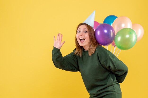 Vooraanzicht jonge vrouw kleurrijke ballonnen verbergen