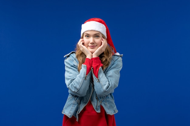 Gratis foto vooraanzicht jonge vrouw lachend op een blauwe achtergrond kleur emotie kerstvakantie