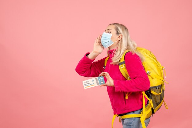 Vooraanzicht jonge vrouw met gele rugzak met kaartje iemand bellen