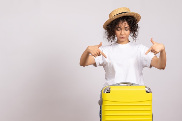 Vooraanzicht jonge vrouw met gele tas die zich voorbereidt op een reis op een witte achtergrond vlucht rust reis toeristisch vakantie vliegtuig zon