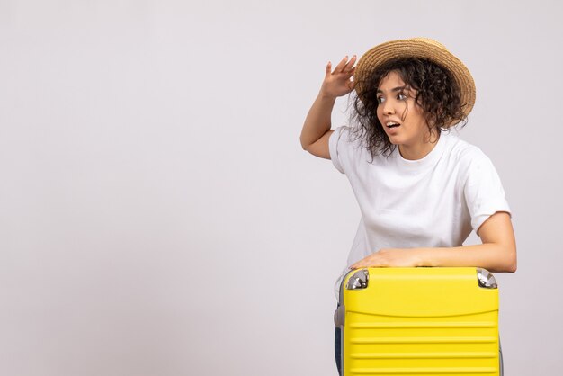 Vooraanzicht jonge vrouw met gele tas die zich voorbereidt op een reis op een witte achtergrondkleur vakantie vlucht toeristen vliegtuig rust reis