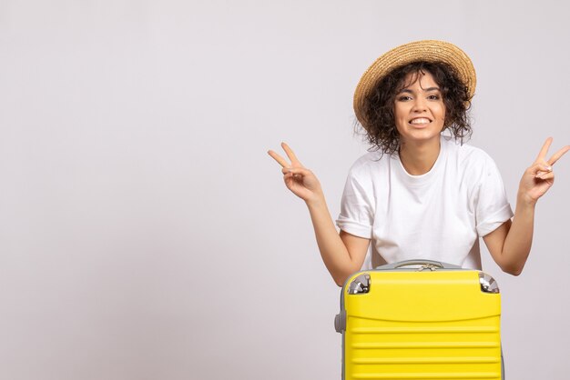 Vooraanzicht jonge vrouw met gele tas die zich voorbereidt op een reis op een witte achtergrondkleur vlucht rest reis vliegtuig toeristische vakantie