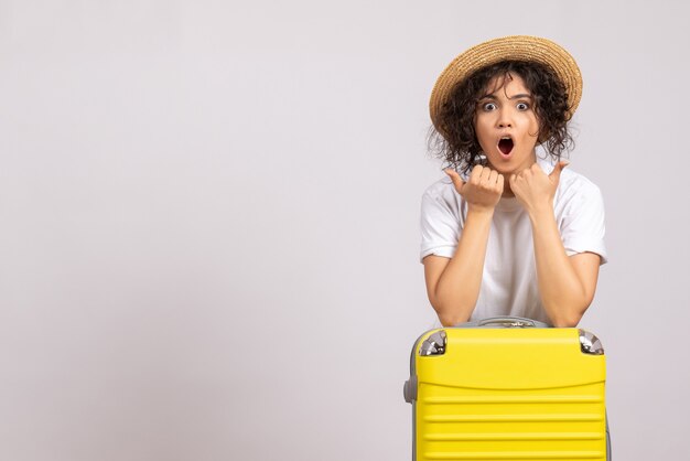 Vooraanzicht jonge vrouw met gele tas die zich voorbereidt op een reis op witte achtergrond vlucht rust reis toeristische vakantie kleur vliegtuig zon