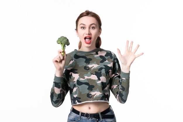 Vooraanzicht jonge vrouw met groene broccoli op witte achtergrond dieet gezondheid voedsel horizontale kleuren salade maaltijd lichaam