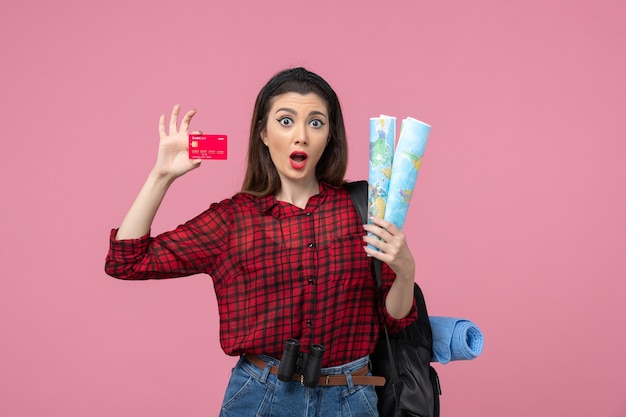 Vooraanzicht jonge vrouw met kaarten en bankkaart op de roze achtergrondkleur vrouw mens