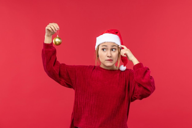 Vooraanzicht jonge vrouw met kerstbal speelgoed, rode kerstvakantie