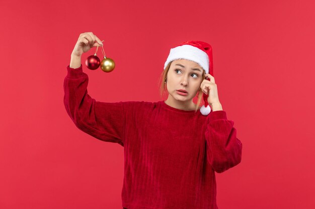 Vooraanzicht jonge vrouw met kerstspeelgoed, vakantie kerstemotie