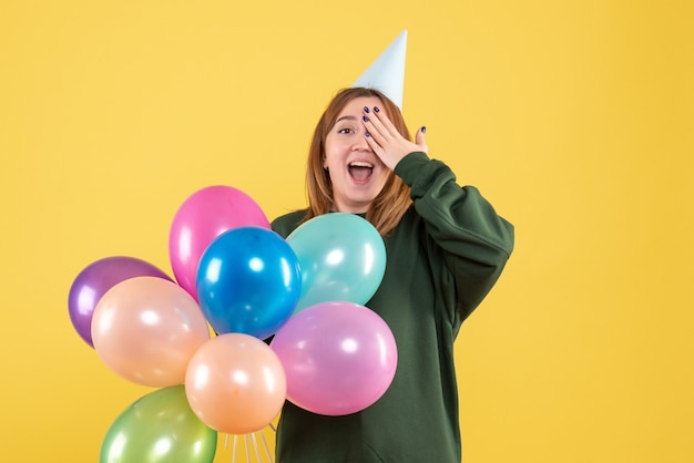 Vooraanzicht jonge vrouw met kleurrijke ballonnen