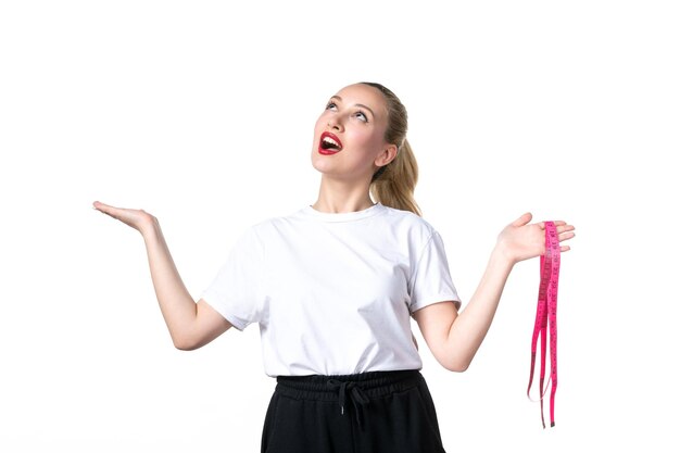 Vooraanzicht jonge vrouw met meetlint op witte achtergrond heup huid taille meten gewicht schaal verliezen afslanken