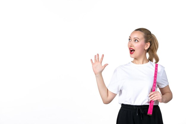 Vooraanzicht jonge vrouw met meetlint op witte ondergrond