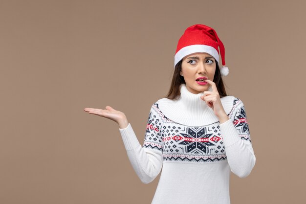 Vooraanzicht jonge vrouw met nerveuze uitdrukking op bruine achtergrond vakantie emotie kerst