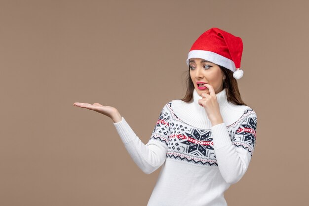 Vooraanzicht jonge vrouw met nerveuze uitdrukking op een bruine achtergrond vakantie emoties kerst