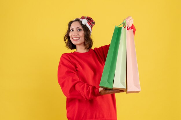 Vooraanzicht jonge vrouw met pakketten van winkelen op geel