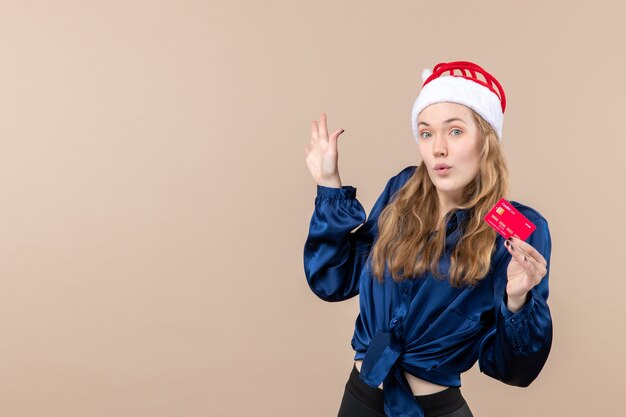 Vooraanzicht jonge vrouw met rode bankkaart op roze achtergrond geld vakantie foto Nieuwjaar xmas emotie