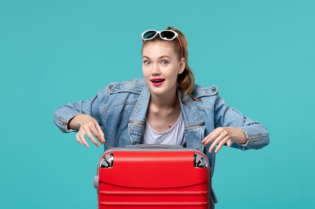 Gratis foto vooraanzicht jonge vrouw met rode zak vakantie op de blauwe ruimte voorbereiden