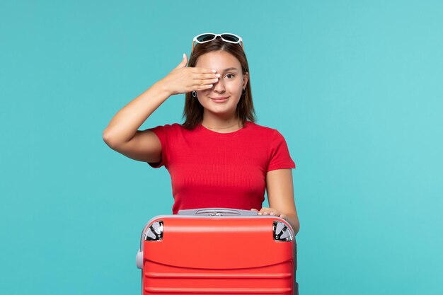 Vooraanzicht jonge vrouw met rode zak vakantie op de blauwe ruimte voorbereiden