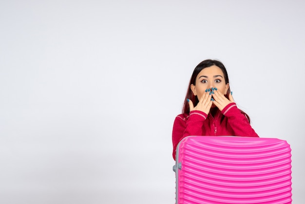 Vooraanzicht jonge vrouw met roze zak geschokt op witte muur emotie vakantie vrouw reis reis vlucht