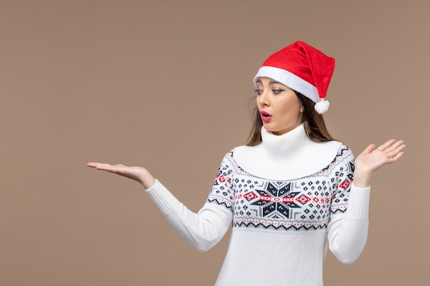 Vooraanzicht jonge vrouw met verwarde uitdrukking op bruin bureau vakantie emotie kerst