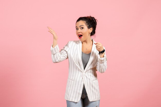 Vooraanzicht jonge vrouw met witte jas op roze achtergrond kleding dame emoties kleur mode vrouw