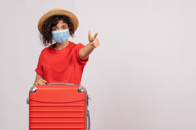 Vooraanzicht jonge vrouw met zak in masker op witte achtergrond kleur virus covid-pandemische vakantie zon toerist