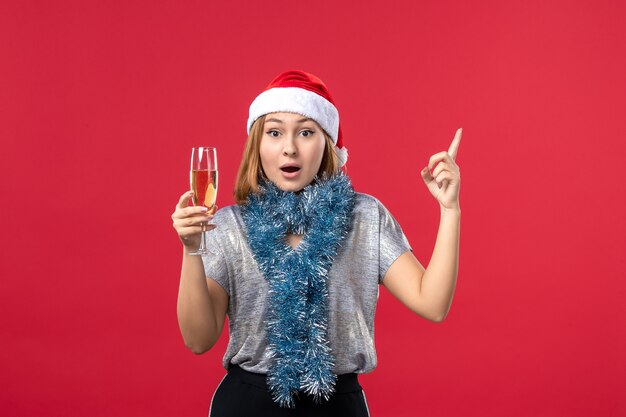 Vooraanzicht jonge vrouw Nieuwjaar vieren op rode muur kleur vakantie kerst