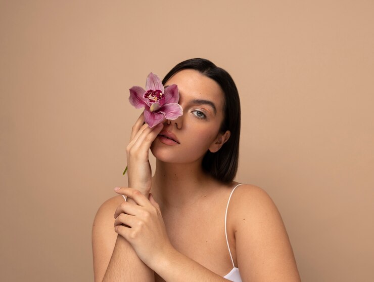 Gratis Foto vooraanzicht jonge vrouw poseren met bloem