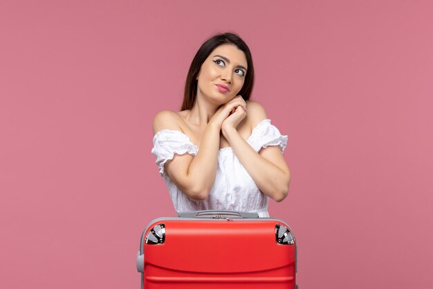 Vooraanzicht jonge vrouw voorbereiding op vakantie met haar tas op de roze achtergrond in het buitenland zeereis reis reis reis