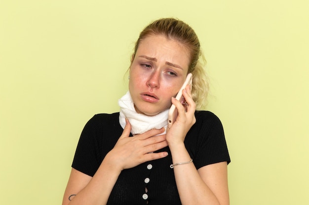 Vooraanzicht jonge vrouw zich erg ziek en ziek voelen praten aan de telefoon op de groene muur ziekte geneeskunde ziekte