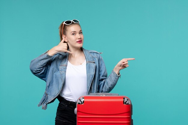 Vooraanzicht jonge vrouw zich klaar voor reis poseren op blauwe ruimte