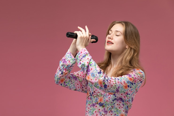 Gratis Foto vooraanzicht jonge vrouw zingen met haar hoofdstem