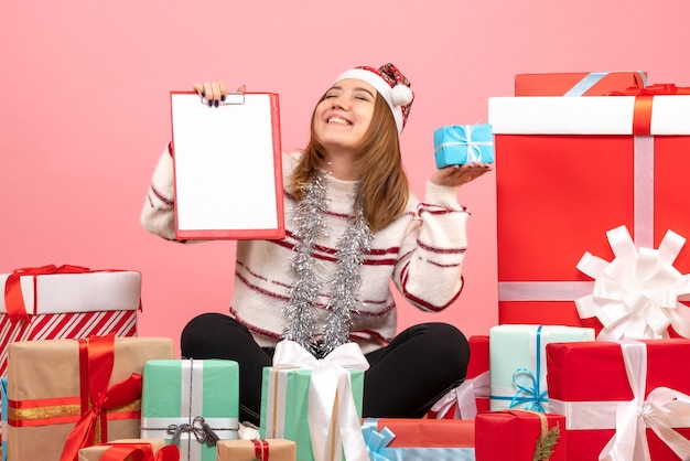 Vooraanzicht jonge vrouw zitten rond kerstcadeautjes met bestandsnota