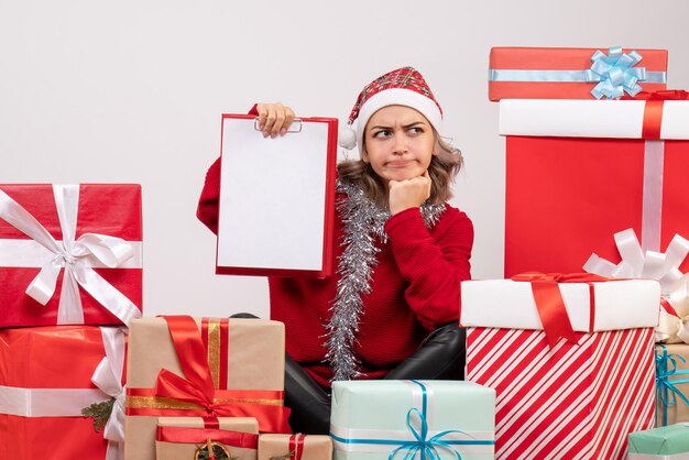 Vooraanzicht jonge vrouw zitten rond kerstcadeautjes met opmerking