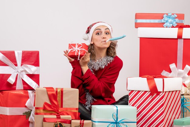 Vooraanzicht jonge vrouw zittend rond kerstcadeautjes