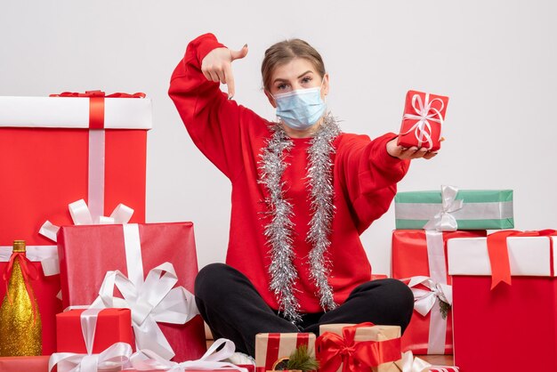 Vooraanzicht jonge vrouw zittend rond kerstcadeautjes