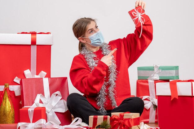 Vooraanzicht jonge vrouw zittend rond kerstcadeautjes