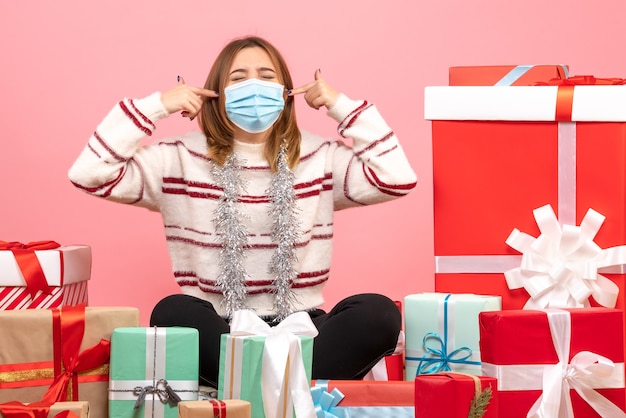 Vooraanzicht jonge vrouw zittend rond kerstcadeautjes