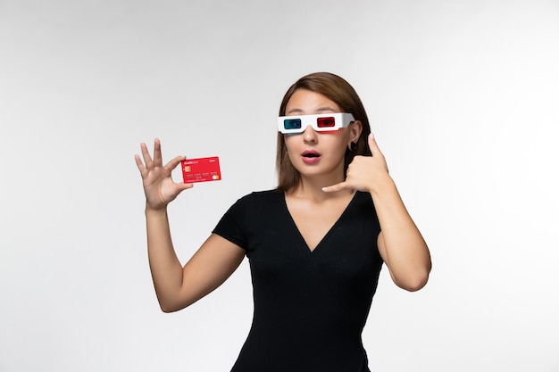 Vooraanzicht jonge vrouwelijke bankkaart in d zonnebril op licht wit oppervlak